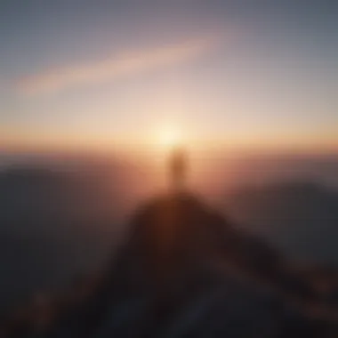 A silhouette standing on a mountain peak at sunrise