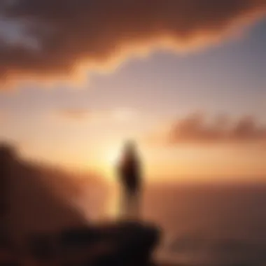 Silhouette of a person standing on a cliff looking at the sunset