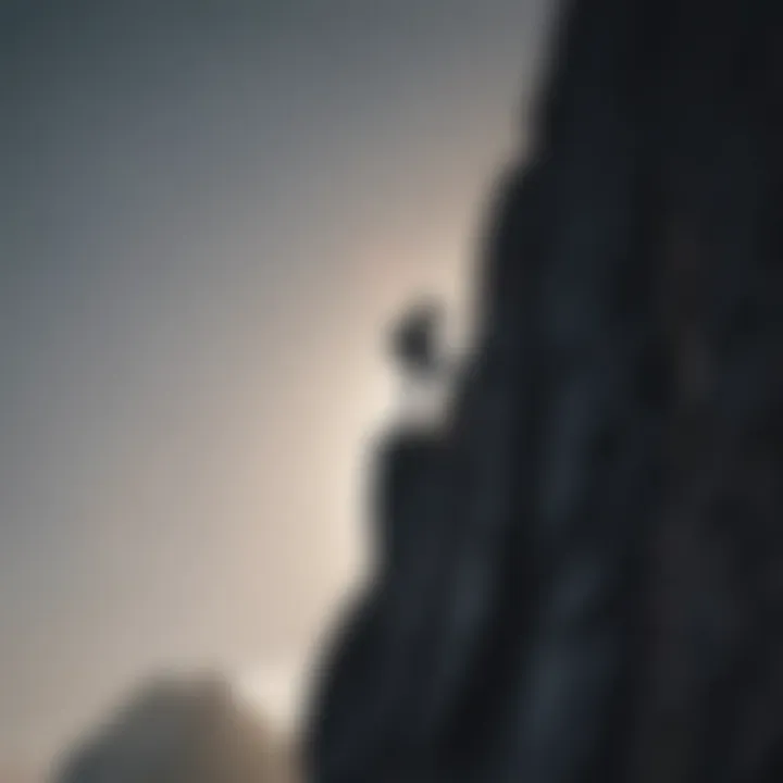 Silhouette of a person climbing a steep mountain