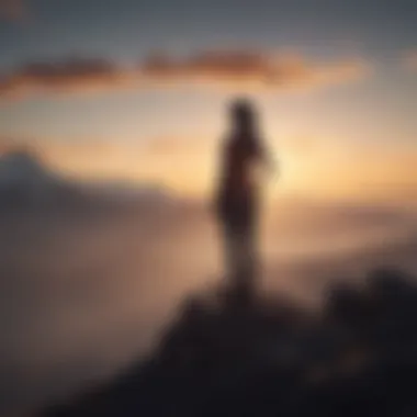 Silhouette of a person standing on a mountain peak at sunrise